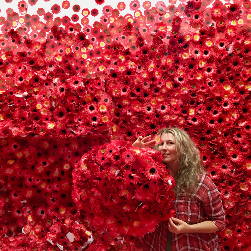 Jesse in front of red flowers